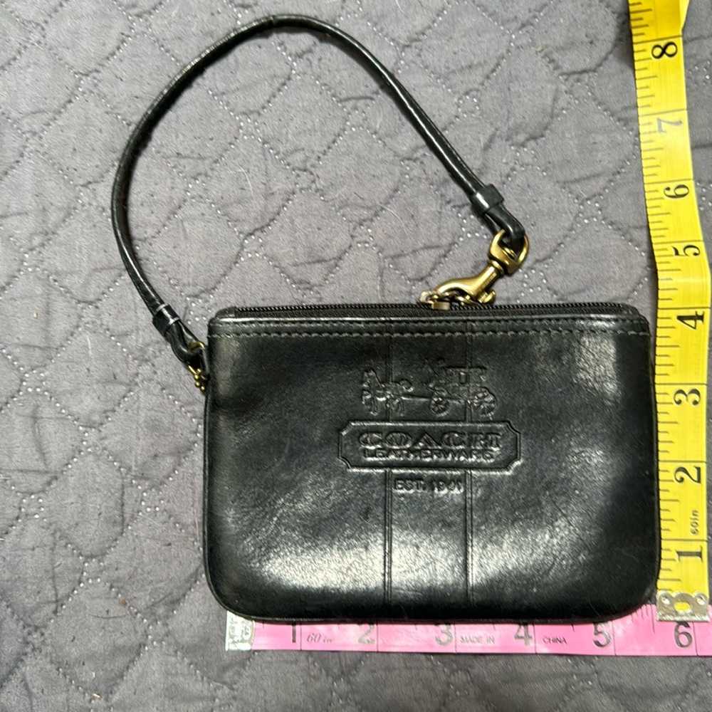 Coach wristlet. Smooth black leather with plaid  interior. Never used.